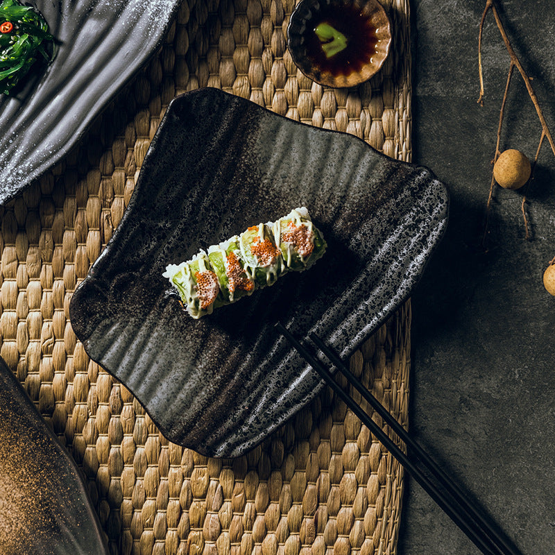 Sushi rolls arranged on plate with chopsticks in rest