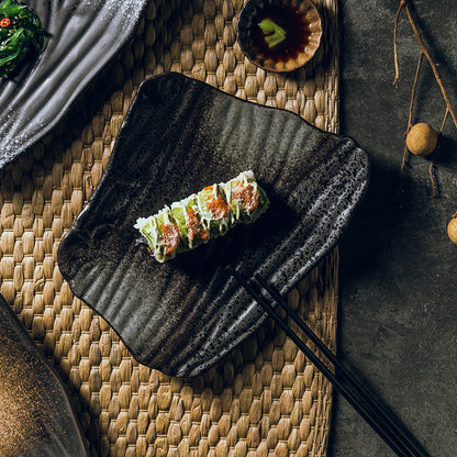 Sushi rolls arranged on plate with chopsticks in rest