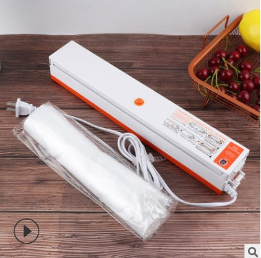 Compact vacuum sealer machine sealing a bag of vegetables on kitchen counter